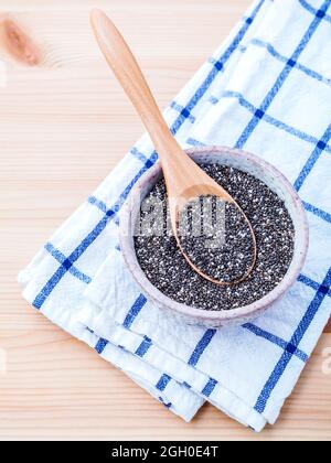 Nahrhafte Chia-Samen in Keramik-Schüssel für die Ernährung Zutaten auf Holz Hintergrund eingestellt. Stockfoto