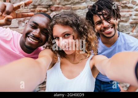 Horizontales Selbstporträt einer attraktiven jungen kaukasischen Frau mit ihren afrikanischen und lateinischen männlichen Freunden Stockfoto