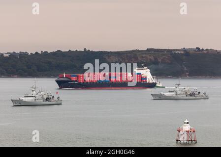 Cobh, Cork, Irland. September 2021. Das Containerschiff Independent Primero kommt im Hafen von Cork an, um eine Frachtbount für Amerika abzuholen, während das Marineschiff LÉ LÉ George Bernard Shaw (P64) und LÉ James Joyce (P62) vor Anker liegen in Cobh, Co. Cork, Irland. - Bild; - David Creedon Credit: David Creedon/Alamy Live News Stockfoto