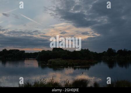 Die Sonne geht mit einem blauen und rosafarbenen Himmel über den Lackford Lakes in Suffolk unter Stockfoto