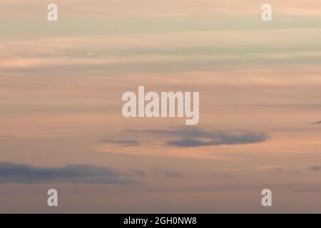 Hintergrund in Pastellfarben, der bei Sonnenuntergang von einem Himmel aus sanften Wolken gestaltet wird. Hauptsächlich orange mit etwas blau, sehr ruhig und wispy. Viel Speicherplatz für Kopien Stockfoto