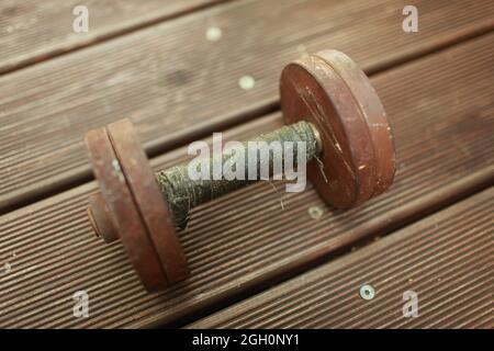 Alte schwere Stahl-Kurzhantel, Griff mit schwarzem Klebeband aus der Nähe aufgewickelt Stockfoto