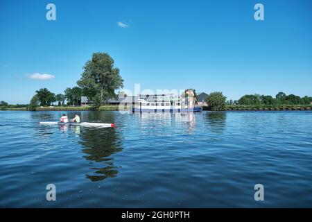 Amersfoort, Hoogland, Niederlande 13. Juni 2021, Fahrradboot, Fähre eemland auf dem Fluss Eem mit Kanu und einem Deich und blauem Himmel in der Stockfoto