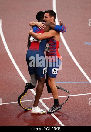 Jarryd Wallace aus den USA und Rennsieger Sherman Guity aus Costa Rica nach dem 200-m-T64-Finale der Männer im Olympiastadion am 11. Tag der Paralympischen Spiele in Tokio 2020 in Japan. Bilddatum: Samstag, 4. September 2021. Stockfoto