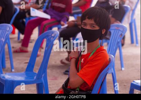 Phnom Penh, Kambodscha. 4. September 2021. Seit über 1/2 Jahren kämpft Phnom Penh gegen einen COVID-Anstieg von 19. Die kambodschanische Regierung bleibt mit ihrem Impfprogramm für 12- bis 17-Jährige auf Kurs. Ein 13-jähriger Junge mit gemischter Rasse (Kambodschanisch-amerikanisch) hält sich nach der Impfung am Arm. Quelle: Kraig Lieb / Alamy Live News Stockfoto