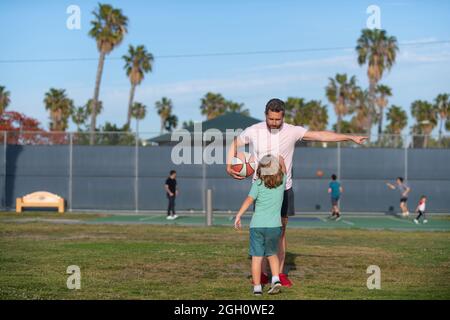 Junge Kind hören Mann Trainer erklären Basketballregeln auf Sportplatz, Sporttraining Stockfoto