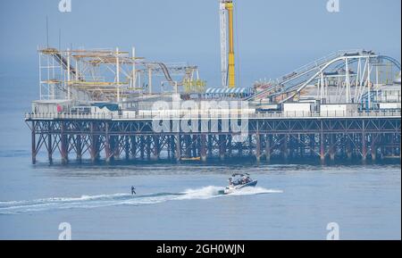 Brighton, Großbritannien. 4. September 2021 - Ein Wasserskifahrer nutzt die heißen, sonnigen und ruhigen Bedingungen am Brighton Palace Pier, da das Wetter in den nächsten Tagen heiß und sonnig sein wird. : Credit Simon Dack / Alamy Live News Stockfoto