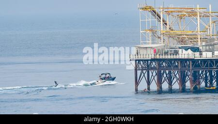 Brighton, Großbritannien. 4. September 2021 - Ein Wasserskifahrer nutzt die heißen, sonnigen und ruhigen Bedingungen am Brighton Palace Pier, da das Wetter in den nächsten Tagen heiß und sonnig sein wird. : Credit Simon Dack / Alamy Live News Stockfoto