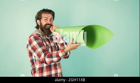 Männlicher Hipster mit modisch gepflegtem Haar und Bart sprechen in Lautsprecher, Informationen Stockfoto
