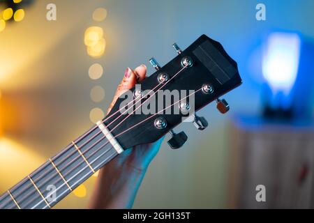 Nahaufnahme des Mädchens Hand Tuning Acoustic Guitar durch Änderung Kopfstock vor dem Üben Stockfoto