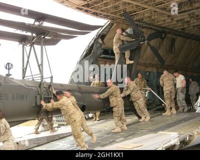 Soldaten der 12. Combat Aviation Brigade aus Ansbach, Deutschland, entlasten am 28. April 2012 einen AH-64 Apache-Hubschrauber aus einem Frachtflugzeug der C5 Galaxy in Mazar e Sharif, Afghanistan. Die Brigade setzt sich für die Operation Enduring Freedom in das afghanische Regionalkommando Nord ein. (Foto von Maj. John C. Crotzer) Stockfoto