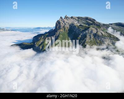 LUFTAUFNAHME. Aiguille de Varan (Höhe: 2544m), umgeben von Wolken in niedriger Höhe am Morgen. Passy, Haute-Savoie, Frankreich. Stockfoto