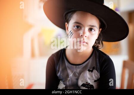 Porträt des kaukasischen kleinen Kindes verkleidet als Hexe für Halloween-Party. Platz für Text. Stockfoto