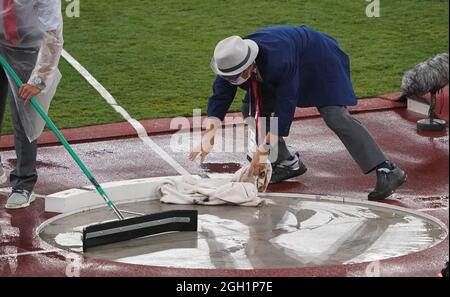 Tokio, Japan. September 2021. Paralympics: Leichtathletik, Männer, Finale, Kugelschuss, F63, Im Olympiastadion. Helfer reinigen den Ring von Regenwasser. Kredit: Marcus Brandt/dpa/Alamy Live Nachrichten Stockfoto