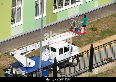 Nischni Nowgorod, Russland, Gagarin Avenue 101 b, Schule Nr. 34. 08.26.2021. Eine Frau, Angestellte einer Reinigungsfirma, wäscht die Fenster des Gebäudes Stockfoto