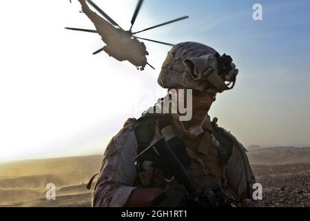 Petty Officer 3rd Class Donte Veals, ein Korpsmann mit der Personal Security Ablösung der 1. Marine Division (Forward), bietet Sicherheit in der Hubschrauberlandezone Barton, als ein CH-53E Superhengst vom Marine Heavy Helicopter Squadron 361, 3rd Marine Aircraft Wing (Fwd), am 16. August abhebt. HMH-361 transportierte Kalbfleisch, 16 Marineinfannen und sechs Geologen in das entlegene Gebiet zur Unterstützung der Operation Centrum, um Gesteinsproben auf der Suche nach seltenen wertvollen Erdelementen zu sammeln. Das bergige Gelände machte das Gebiet für das Fahrzeug unzugänglich, und mit einem engen HLZ und schwergewichtigen helos erlaubt die Stockfoto