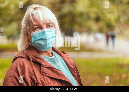 Coronavirus, COVID-19 Pandemiekonzept. Blonde Frau trägt Gesichtsmaske schützend für Krankheit Virus Stockfoto