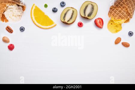 Kegel und bunten verschiedene Früchte Himbeere, Heidelbeere, Erdbeere, Orange Slice, halbieren, Kiwi, Apfel, Tomate und Pfefferminze Blätter setup auf weißen Hinterg Stockfoto