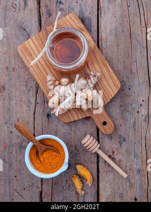 Alternative Pflege - selbstgemachte Peelings curcumin Pulver, Honig und curcumin Wurzeln bis auf alten Holztisch gesetzt. Stockfoto