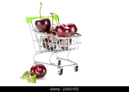 Ein Bund dunkelroter, frischer Kirschen auf einem Spielzeugwagen. Isoliert auf weißem Hintergrund. Stockfoto