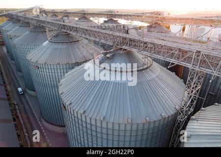 Odessa, Ukraine - Аugust 14, 2021: Getreideterminals des modernen Handelshafens. Silos zur Lagerung von Getreide in Strahlen untergehenden Sonnenlichtes, Draufsicht von Quadco Stockfoto