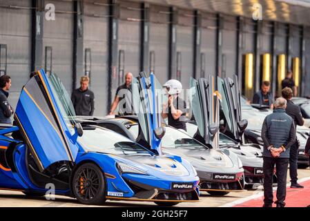 Die Türen der McLaren Supersportwagen öffnen sich während eines McLaren-Fahrerevents auf der Boxengasse auf dem Silverstone Circuit Stockfoto