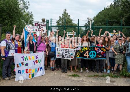 40 Jahre nach dem ursprünglichen marsch aus Cardiff, der am 5. September 1981 das Greenham Womens Peace Camp initiierte, treffen Frauen am Greenham Common Gates ein. Sie rekonstruierten den marsch aus Cardiff rechtzeitig zu den Feierlichkeiten zum 40. Jahrestag, die für den 5. September 2021 geplant waren. Das ursprüngliche Greenham Womens Peace Camp stand im Widerspruch zur Aufstellung von US-amerikanischen nuklearen Cruise-Raketen auf der Basis der RAF. Die Proteste dauerten dort während der 1980er Jahre an, mit Versuchen, den Bau der Silos und die Bewegung der Raketen zu stören, die schließlich 1991 entfernt wurden. Die letzten Frauen verließen das Lager 2000 nach 19 Jahren. Stockfoto