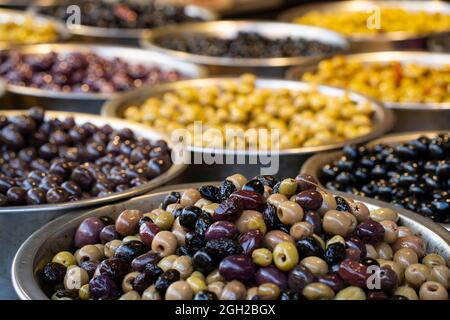 Ein Bild mit geringer Tiefenschärfe einer Vielzahl von Oliven auf einem Marktstand. Stockfoto