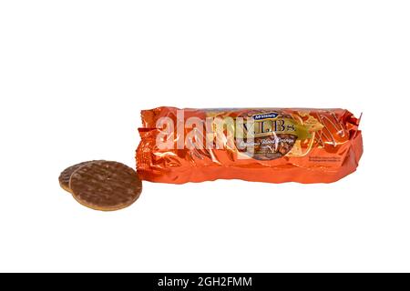 Eine geöffnete Packung mit McVitie's köstlichen Karamell- und Schokoladenkeksen mit Blutorange-Geschmack und zwei Keksen neben der Packung. Stockfoto