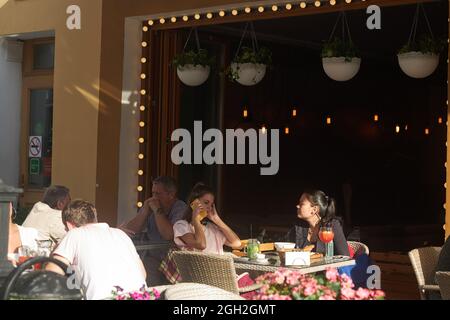 Moskau, Russland - am 31. August 2021 essen die Menschen an einem sonnigen Tag in einem Straßencafé auf einer Veranda im Stadtzentrum zu Mittag. Kusnetsky Most Stockfoto