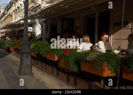 Moskau, Russland - am 31. August 2021 essen die Menschen an einem sonnigen Tag in einem Straßencafé auf einer Veranda im Stadtzentrum zu Mittag. Kusnetsky Most Stockfoto