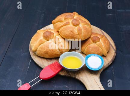 Pan de Muerto auf Holzbrett auf dunklem Hintergrund. Speicherplatz kopieren. Tag der Toten. Mexikanischer Urlaub. Mexikanisches Essen. Stockfoto