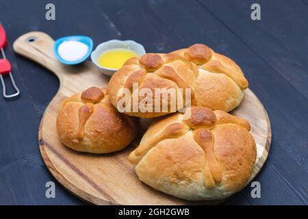 Pan de Muerto auf Holzbrett auf dunklem Hintergrund. Speicherplatz kopieren. Tag der Toten. Mexikanischer Urlaub. Mexikanisches Essen. Stockfoto