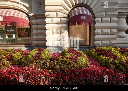 Moskau, Russland - 31. August 2021, Blumenbeete mit Begonien und verschiedene Arten von Coleus in roten Tönen schmücken den Eingang zum KAUGUMMI auf der Nikolskaja Straße Stockfoto