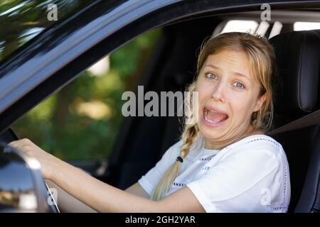 Junge hübsche Frau hat Angst im Auto Stockfoto