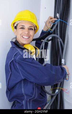 Weibliche Elektriker arbeiten mit Kabel Stockfoto