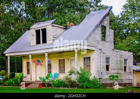 Eine amerikanische Flagge fliegt am 31. August 2021 in Bayou La Batre, Alabama, auf ein feuerbeschädigtes Haus. Das Haus im Creole Plantation-Stil wird gerade renoviert.