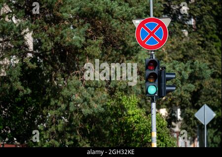 Straßenschild und Verkehrssemaphore mit Grün und Licht vor dem unschärfenden Hintergrund Stockfoto