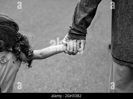 Ein Mann hält die Hand seiner Enkelin, während sie in Santa Fe, New Mexico, spazieren Stockfoto