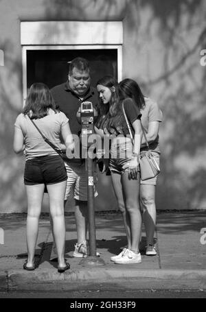 Eine Familie besucht Santa Fe, New Mexico, und kauft Zeit auf einem Parkmesser. Stockfoto