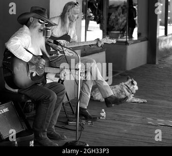 Johnny Lloyd, ein bekannter Straßenkünstler in Santa Fe, New Mexico, tritt auf einem Bürgersteig gegenüber der historischen Plaza der Stadt auf. Stockfoto