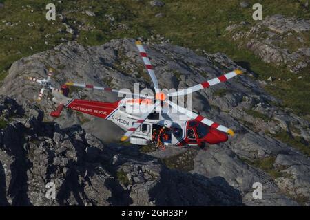 Ein AW189-Hubschrauber der Küstenwache Ihrer Majestät führt eine Bergrettung an der Nordwand von Ben Nevis, schottische Highlands, Großbritannien, durch Stockfoto