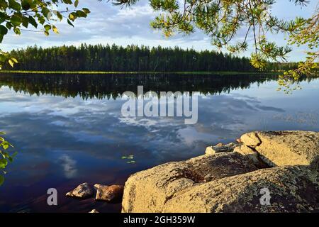 Wunderschöne karelische Landschaft - Felsen, Pinien, Himmel und Wasser. Pongoma-See, Nord-Karelien, Russland Stockfoto