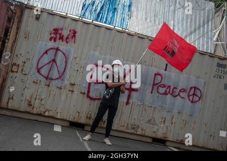 Bangkok, Thailand. September 2021. Während der Demonstration winkte ein prodemokratischer Protestler mit einer Flagge vor den intermodalen Containern.Pro-Demokratie-Demonstranten versammelten sich an der Kreuzung Ploenchit, bevor sie die Sukhumvit-Straße entlang marschierten und den Rücktritt von Prayut Chan-O-Cha, Thailands Premierminister, forderten, weil die Regierung die COVID-19-Krise und die Reform der Monarchie nicht bewältigt hat. Kredit: SOPA Images Limited/Alamy Live Nachrichten Stockfoto
