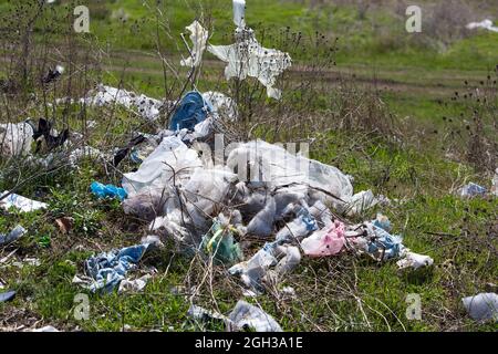 Übersät mit Müllfeldern und Straßenrändern. Kamine aus Müll und Reifen. Kunststoff, Polyethylen, Flaschen, Haushalts- und Baugarbag Stockfoto