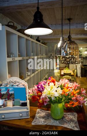 Ein Blumenstrauß ALSTROMERIA in einer Vase im Inneren des Restaurants, Café. Stockfoto