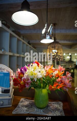 Ein Blumenstrauß ALSTROMERIA in einer Vase im Inneren des Restaurants, Café. Stockfoto