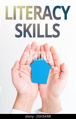Schild mit der Anzeige der Fähigkeiten zur Alphabetisierung. Wort für alle Kenntnisse und Fähigkeiten müssen Informationen Hand Holdign Paper House mit Care Real Estate und bewerten Stockfoto
