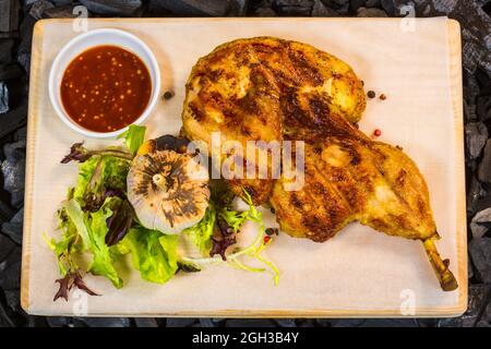 Gebratenes Huhn. Gebratene Hähnchenschenkel mit Gemüsegarnitur Stockfoto