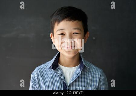 Glücklich asiatische Kind junge Schüler Blick auf Kamera auf Tafel Hintergrund. Stockfoto